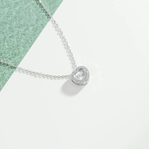 Elegant stainless steel heart pendant necklace featuring a radiant sunburst texture and pavé stones