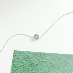 Elegant stainless steel heart pendant necklace with fine chain on marble surface