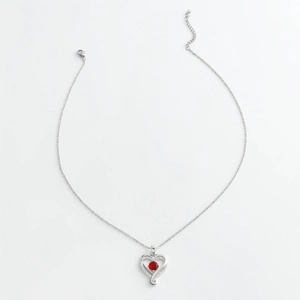 Silver heart pendant necklace with red zircon center stone on white background