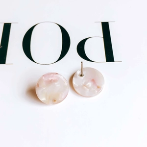 Detail of pink and white marble texture resin round stud earrings on minimal card