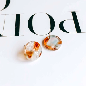 Macro detail of round marble texture acetic acid resin earrings with silver steel pins