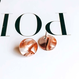 Macro view of round acetate earrings with brown marble texture and steel pin backings