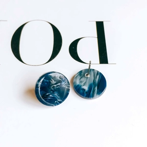 Macro view of blue marble acetate disc earrings with silver steel needle studs