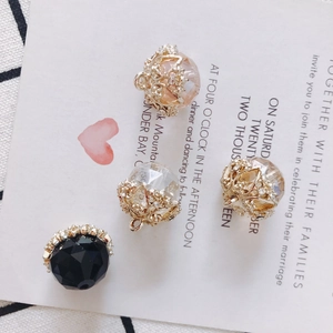Detailed macro of crystal glass charms with gold filigree and small rhinestones