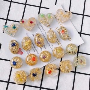 Vue détaillée des perles de résine DIY avec feuilles d'or et fleurs séchées de formes variés