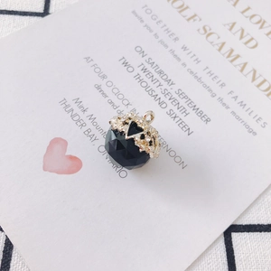 Macro shot of faceted black glass bead pendant with gold rhinestone floral cap