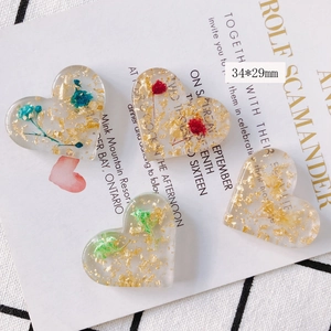 Détail de pendentifs cœur en acrylique 34x29mm avec fleurs séchées et feuille d'or