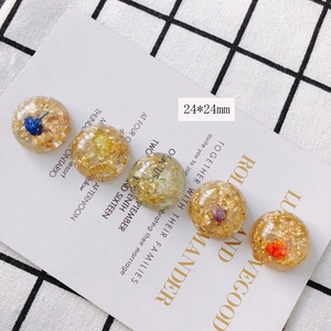 Détail de pendentifs ronds en acrylique de 24 mm avec feuille d'or et fleurs séchées