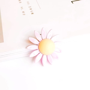 Detalle de un colgante de margarita rosa y amarilla para creación de joyas DIY