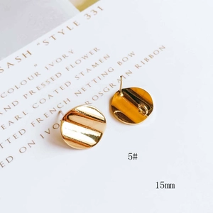 Dettaglio di ciondoli geometrici curvi placcati oro 15mm per creazione di gioielli