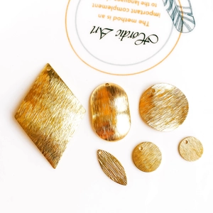 Detailed view of assorted gold plated brushed metal geometric charms for DIY jewelry making