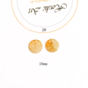 Macro detail of 10mm round brushed brass jewelry pendant for DIY earring crafts