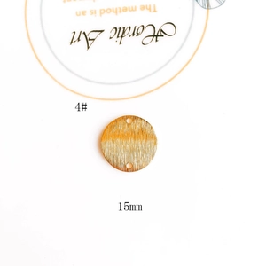 Macro view of a 15mm gold-plated brushed metal round pendant with double holes for DIY