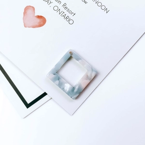 Macro-opname van een vierkante holle acryl hanger met een lichtblauwe marmeren textuur