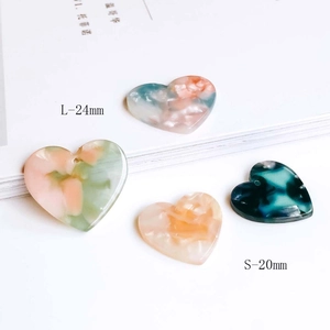 Detailed view of heart-shaped marble resin charms in 20mm and 24mm sizes