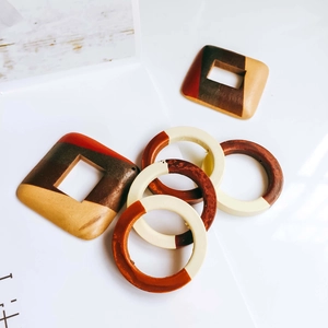Macro shot of geometric wooden earring charms with color blocking in boho vintage style