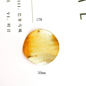 Detailed view of 30mm gold plated round pendant with brushed texture and top hole