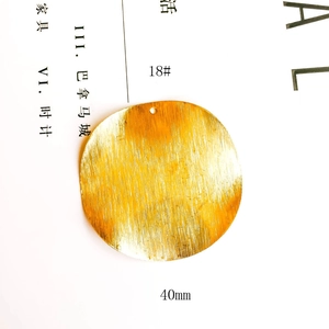 Detailed view of a 40mm round gold-plated jewelry pendant with brushed metal texture