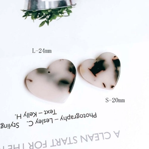 Detail view of heart-shaped marble acetate pendants in 24mm and 20mm sizes for DIY jewelry