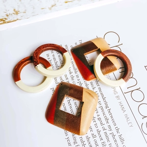 Macro shot of geometric wood earrings featuring concentric color block textures on a magazine