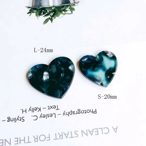Detail of marble pattern acetate heart charms in 20mm and 24mm sizes for jewelry making