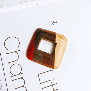 Detail view of square wooden earring pendant featuring tricolor spliced natural textures
