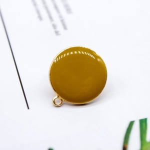Makroaufnahme von senfgelbem Emaille-Anhänger mit Goldmetallrahmen für DIY-Schmuck