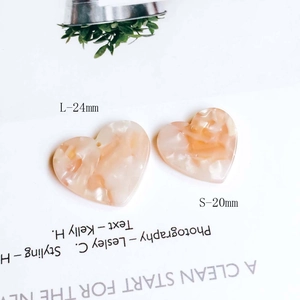 Detail of peach marble texture heart pendants in 20mm and 24mm sizes for DIY jewelry