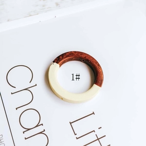 Macro detail of round wood and resin pendant with marbled texture for DIY earrings