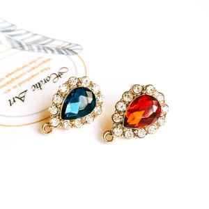 Detailed view of pear-cut crystal teardrop charms in red and blue with gold plating