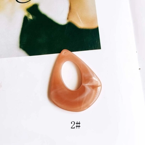 Macro detail of amber resin teardrop pendant with marble texture and hollow design