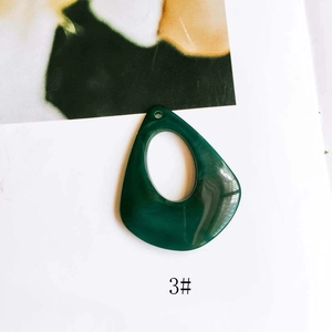 Detail of dark green teardrop resin pendant for DIY jewelry with pre-drilled hole