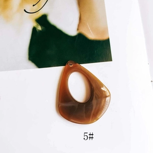 Detailed view of amber brown resin teardrop charms for DIY earring and jewelry making