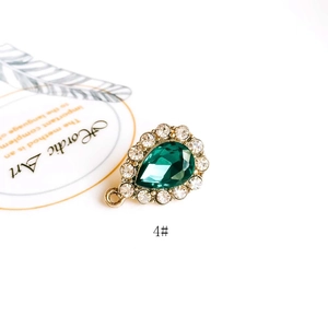 Macro detail of tear drop green gemstone pendant with white zircon halo for DIY jewelry