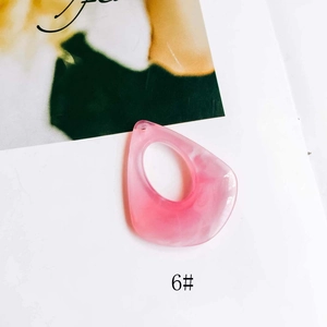 Detailed close-up of pink marble resin teardrop charms for DIY earring and jewelry making