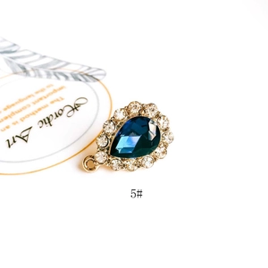 Macro shot of a teardrop-shaped blue gemstone pendant with sparkling rhinestones and gold base