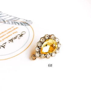 Macro shot of yellow teardrop crystal pendant with rhinestone halo in gold plating