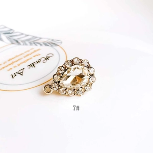 Macro shot of champagne waterdrop gemstone pendant with white diamond halo and gold base