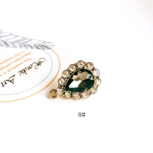Detail of tear drop dark grey gemstone pendant with white zircon halo and gold plating