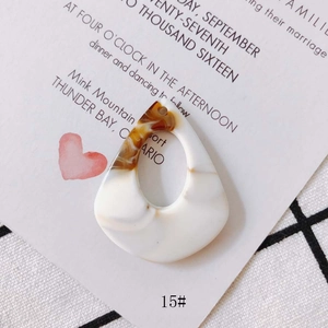 Macro view of water drop resin earring pendant with amber marble texture and small hole