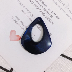 Macro shot of dark blue marble texture teardrop resin charm with hollow center for DIY jewelry