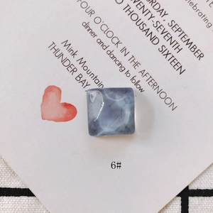 Détail de la breloque carrée en résine marbrée bleue avec texture ondulée