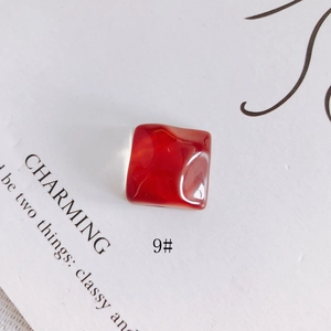 Vue macro d'un charme carré en résine rouge foncé avec texture irrégulière d'ondulations d'eau