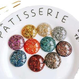 Patchs ronds en résine et feuilles d'or colorées présentés sur une assiette en céramique