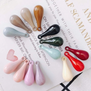 Macro detail of colorful teardrop resin pendants with hole for DIY jewelry making