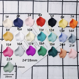 Flat lay of 22 colorful matte resin flower petal charms for DIY jewelry making
