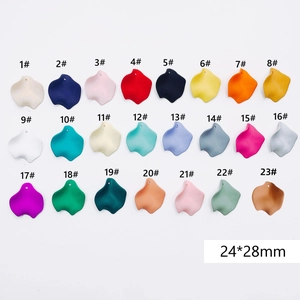 Flat lay of 23 colored resin flower petal charms with holes for DIY jewelry making