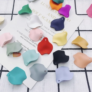 Flat lay of colorful matte resin flower petals with pre-drilled holes for DIY jewelry