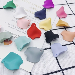 Close-up of matte resin petal pendants in Morandi colors with pre-drilled holes for DIY jewelry