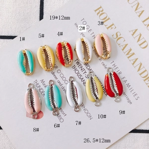 Detailed macro view of colorful shell shaped enamel gold pendants in various vibrant sizes